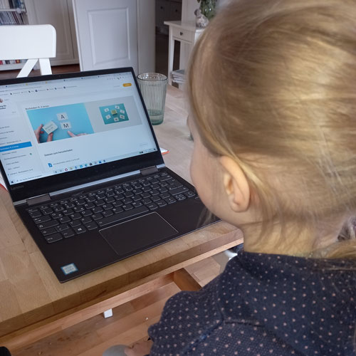 Mädchen sitzt vor dem Laptop und macht den Online Lesekurs von Sandy Mohns